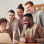 People Smiling Over a Desk