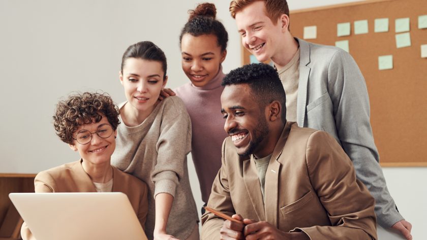 People Smiling Over a Desk